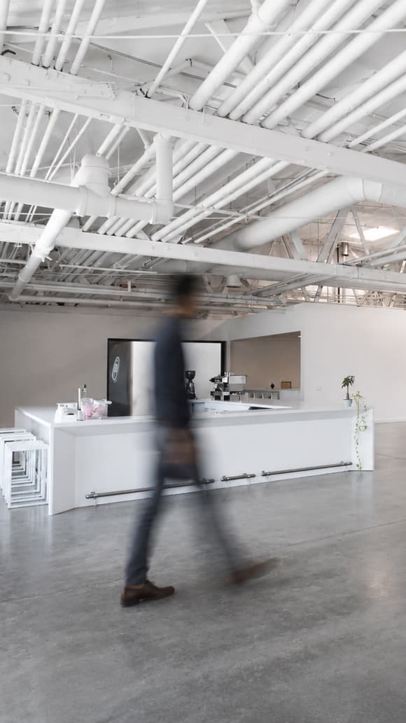 Bright Factory workspace with people moving through a polished open office