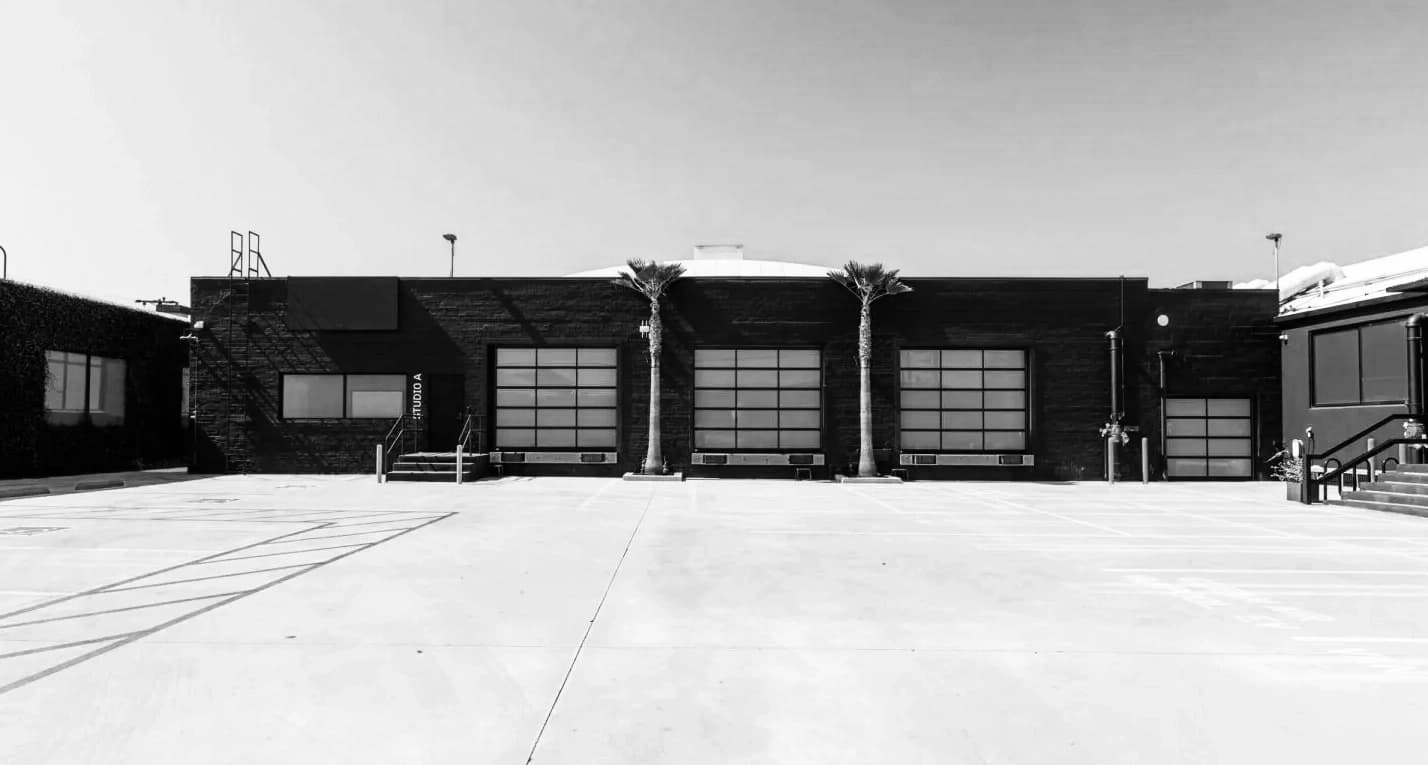 Factory HQ exterior parking court with black studio buildings